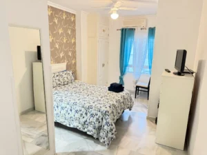 Dormitorio luminoso con baño en suite y armario empotrado en piso de Fuengirola Centro