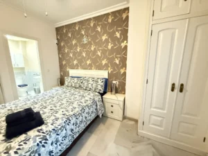 Dormitorio luminoso con baño en suite y armario empotrado en piso de Fuengirola Centro