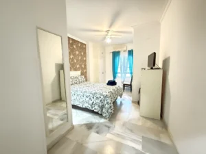 Dormitorio luminoso con baño en suite y armario empotrado en piso de Fuengirola Centro