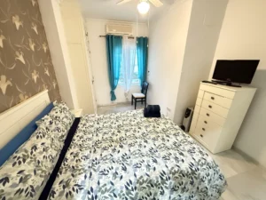 Dormitorio luminoso con baño en suite y armario empotrado en piso de Fuengirola Centro