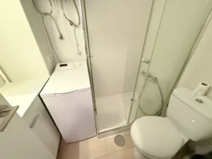 Baño completo con plato de ducha y lavadora en estudio Calypso 1