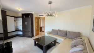 Salón comedor con muebles a medida y acceso a terraza acristalada con vistas al mar en Los Pacos Fuengirola
