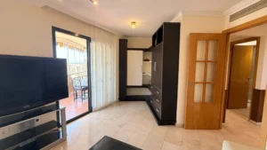 Salón comedor con muebles a medida y acceso a terraza acristalada con vistas al mar en Los Pacos Fuengirola