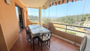 Salón comedor con muebles a medida y acceso a terraza acristalada con vistas al mar en Los Pacos Fuengirola