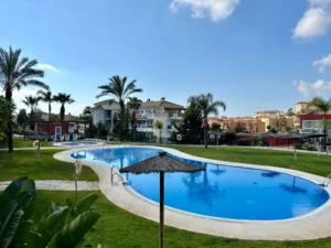 Piscina comunitaria climatizada y jardines tropicales en urbanización privada de Riviera del Sol