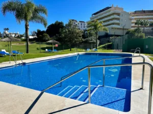 Piscina comunitaria climatizada y jardines tropicales en urbanización privada de Riviera del Sol